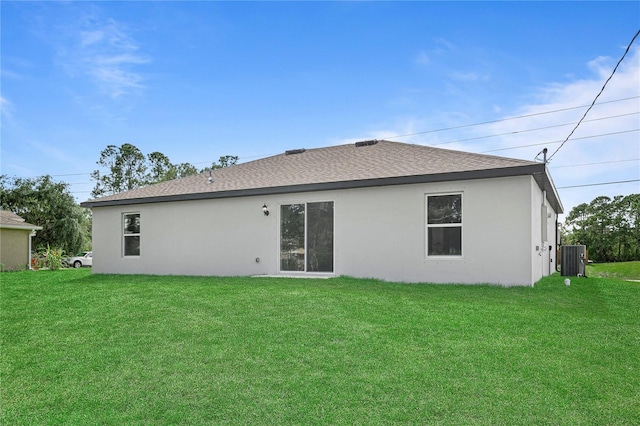 rear view of house with a lawn and central air condition unit