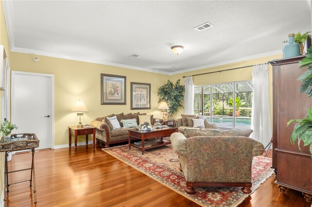 living room with wood-type flooring and crown molding