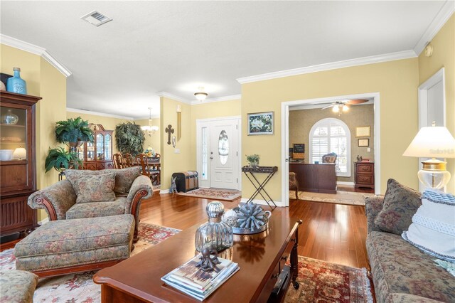 living room with hardwood / wood-style flooring, ceiling fan, and crown molding