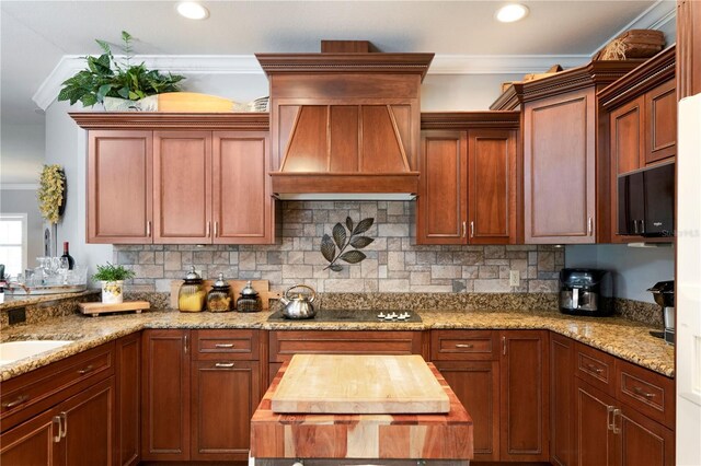 kitchen with wood counters, backsplash, premium range hood, ornamental molding, and black electric cooktop