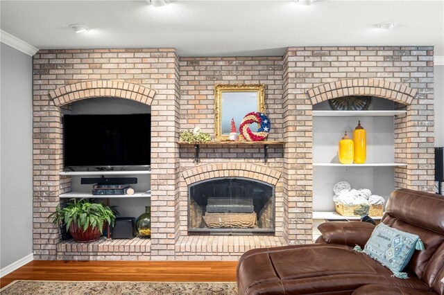 living room featuring a fireplace, hardwood / wood-style floors, and ornamental molding