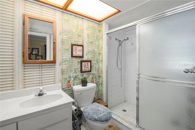 bathroom featuring vanity, toilet, and a shower with door