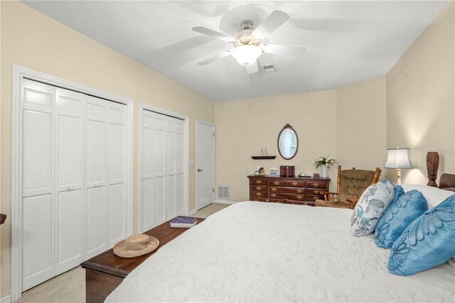 bedroom with ceiling fan and two closets