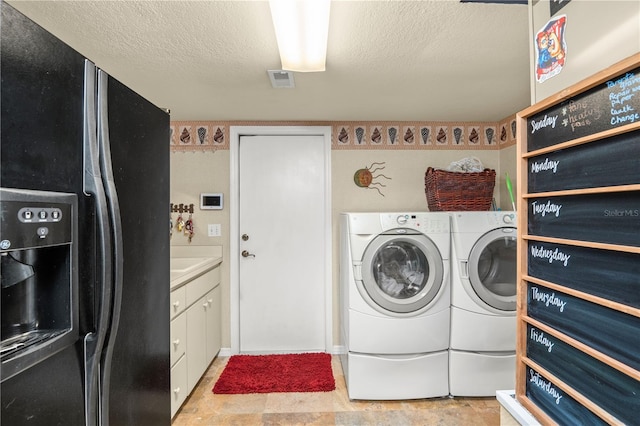 washroom with washer and clothes dryer, cabinets, and a textured ceiling