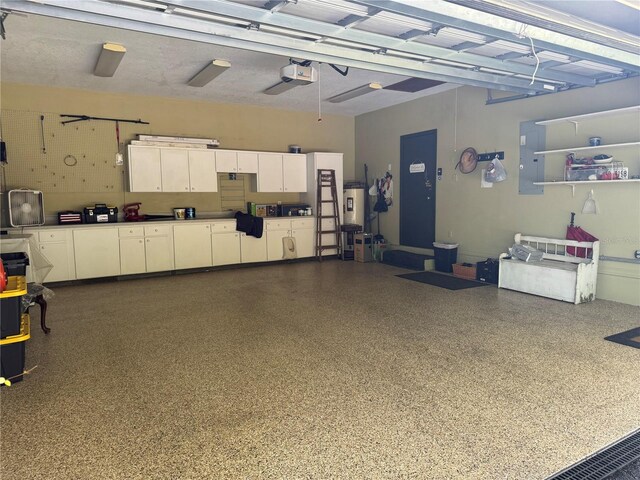 garage featuring electric panel, a garage door opener, and water heater