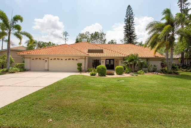 mediterranean / spanish-style house with a garage and a front yard