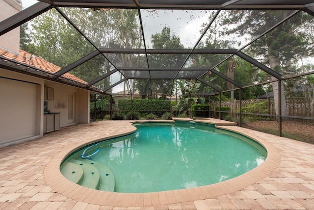 view of swimming pool featuring a lanai and a patio