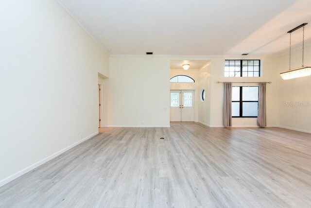 interior space with light hardwood / wood-style floors and ornamental molding