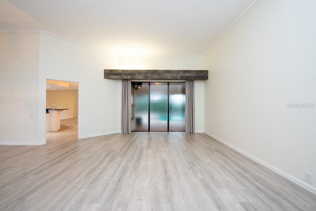 spare room with light hardwood / wood-style flooring, elevator, and ornamental molding