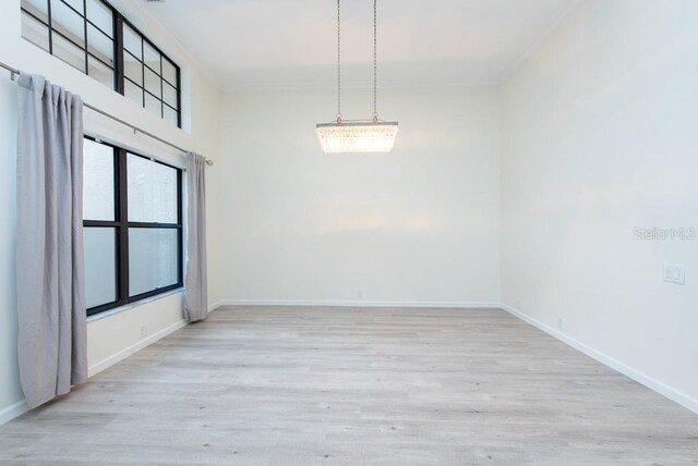 unfurnished room with an inviting chandelier and wood-type flooring