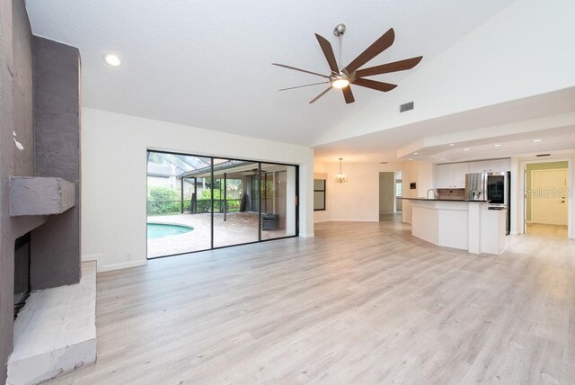 unfurnished living room with ceiling fan, light hardwood / wood-style flooring, and high vaulted ceiling