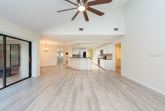 unfurnished living room featuring light hardwood / wood-style floors, ceiling fan with notable chandelier, and high vaulted ceiling