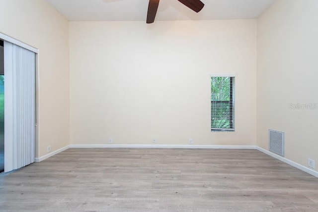 spare room featuring ceiling fan, light hardwood / wood-style floors, and beam ceiling