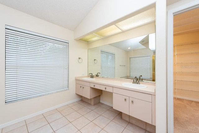 bathroom with vaulted ceiling, double vanity, and tile patterned floors