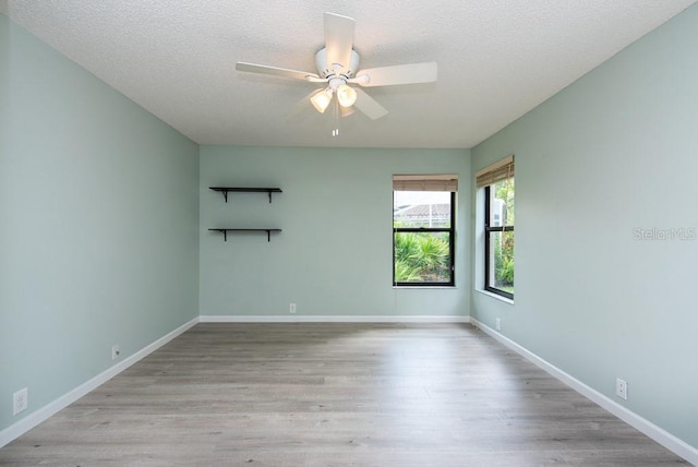 unfurnished room featuring light hardwood / wood-style floors, a textured ceiling, and ceiling fan