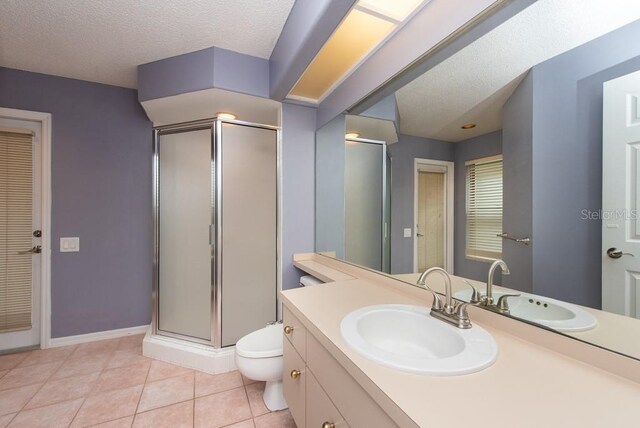 bathroom featuring vanity, walk in shower, toilet, a textured ceiling, and tile patterned flooring