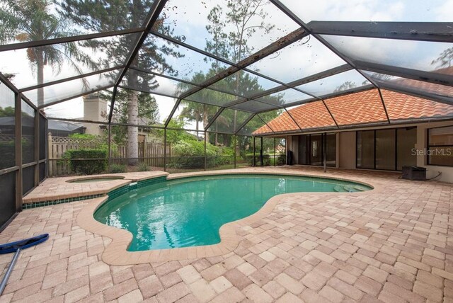 view of pool with an in ground hot tub, a lanai, and a patio area