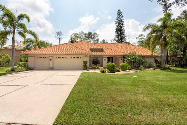 mediterranean / spanish home with a garage and a front yard