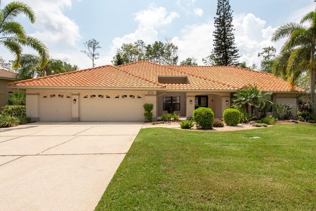 mediterranean / spanish-style house with a garage and a front yard