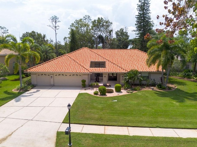 mediterranean / spanish home with a garage and a front lawn