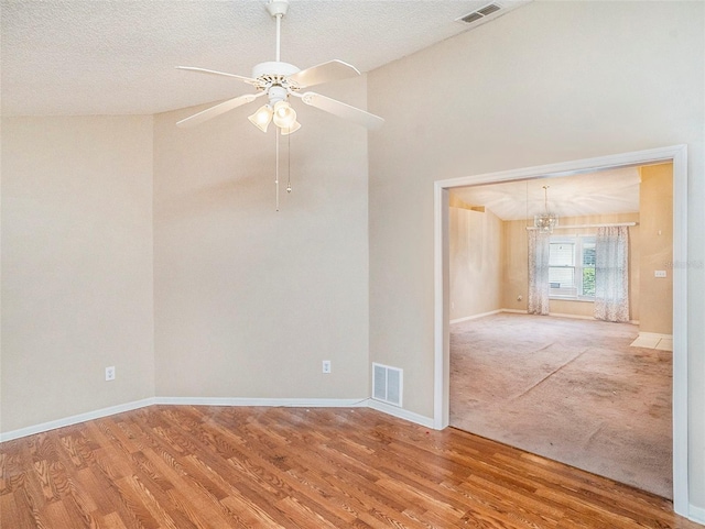 spare room featuring a textured ceiling, high vaulted ceiling, carpet floors, and ceiling fan