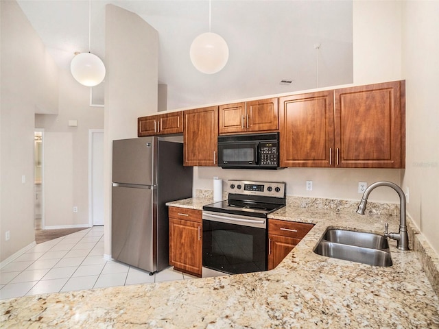 kitchen with stainless steel appliances, sink, decorative light fixtures, light tile patterned flooring, and high vaulted ceiling