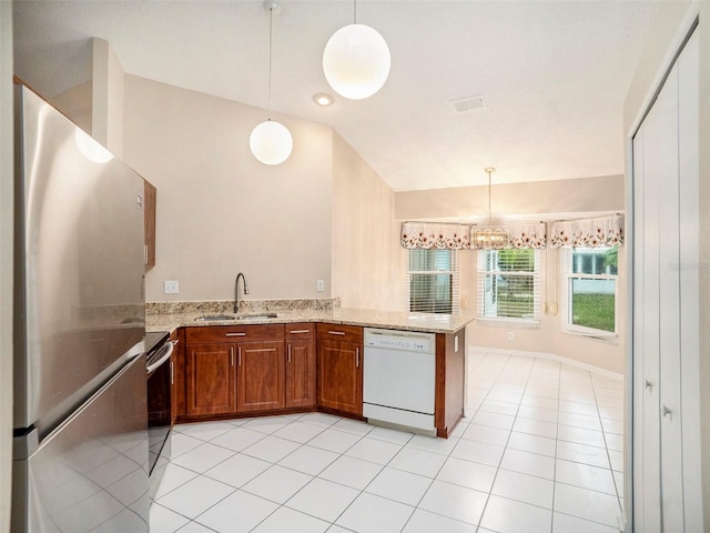 kitchen featuring sink, dishwasher, vaulted ceiling, stainless steel refrigerator, and kitchen peninsula