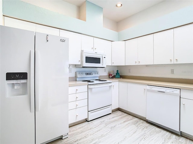 kitchen featuring light countertops, white appliances, and white cabinetry