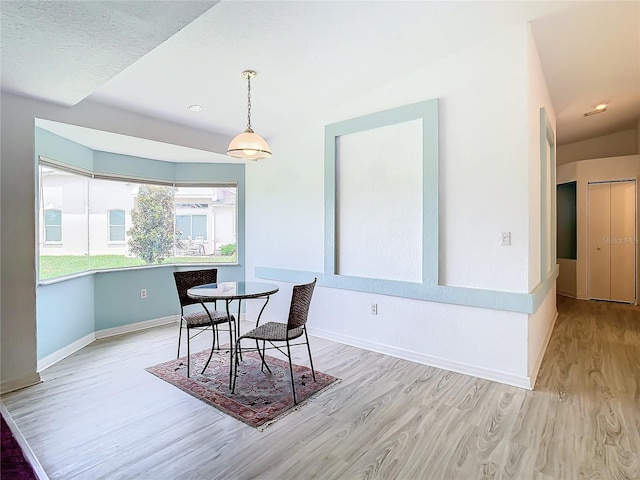 dining area with light wood finished floors and baseboards