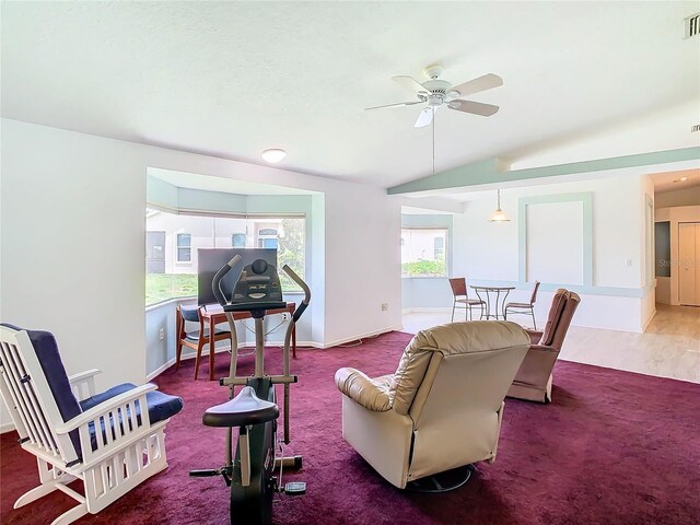 living room featuring lofted ceiling, visible vents, baseboards, a ceiling fan, and dark carpet