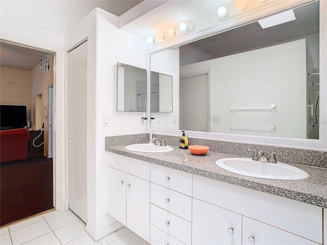 bathroom with double vanity, a closet, a sink, and tile patterned floors