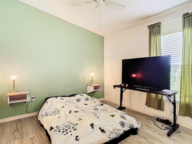 bedroom with a ceiling fan, baseboards, and wood finished floors