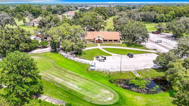 drone / aerial view with view of golf course and a water view