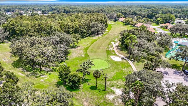 bird's eye view featuring view of golf course and a view of trees