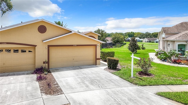 view of front of property featuring concrete driveway, stucco siding, a residential view, an attached garage, and a front yard