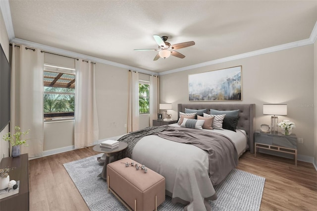 bedroom with light hardwood / wood-style floors, crown molding, and ceiling fan