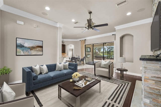 living room with ornamental molding, a textured ceiling, ceiling fan, and light hardwood / wood-style floors