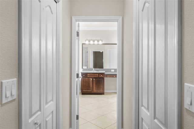 corridor with light tile patterned flooring and sink