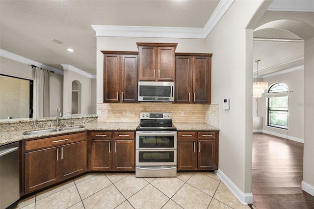 kitchen featuring light hardwood / wood-style floors, sink, ornamental molding, and stainless steel appliances