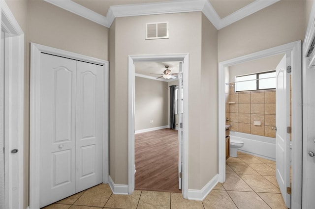 hall with light tile patterned floors and crown molding