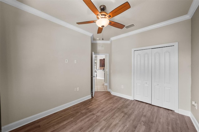 unfurnished bedroom featuring ornamental molding, tile patterned floors, ceiling fan, and a closet