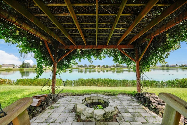 view of patio with a fire pit and a water view