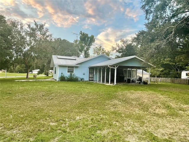 back house at dusk featuring a yard