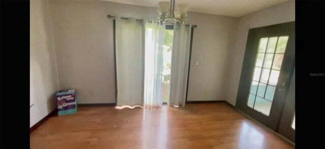 13659 SW 115th Pl, Dunnellon, FL 34432 - unfurnished dining area featuring a chandelier, wood finished floors, and baseboards