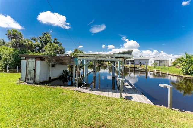 view of dock with a yard and a water view