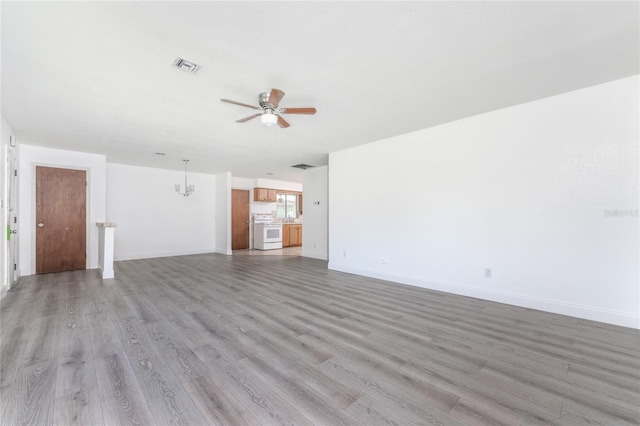 unfurnished living room with ceiling fan with notable chandelier and light hardwood / wood-style flooring