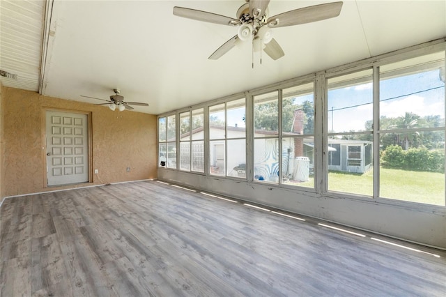 unfurnished sunroom featuring ceiling fan