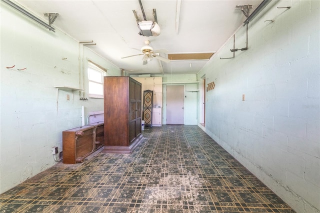 interior space featuring a garage door opener and ceiling fan