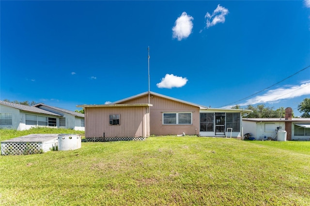 back of property featuring a yard and a sunroom