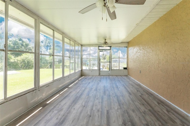 unfurnished sunroom with ceiling fan